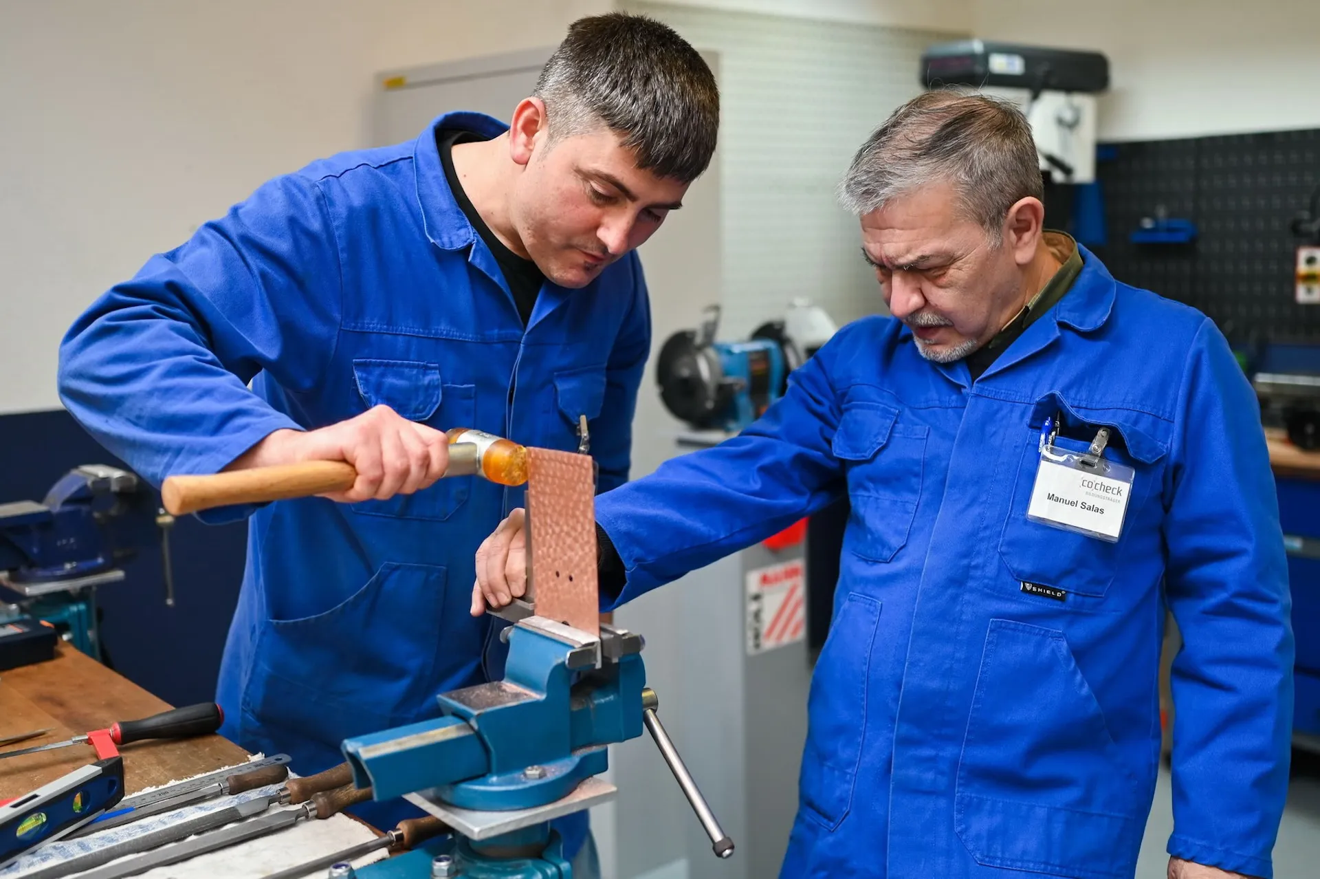 Auszubildender im Metallberuf mit Hammer – authentische Momentaufnahme aus der Unternehmensfotografie.