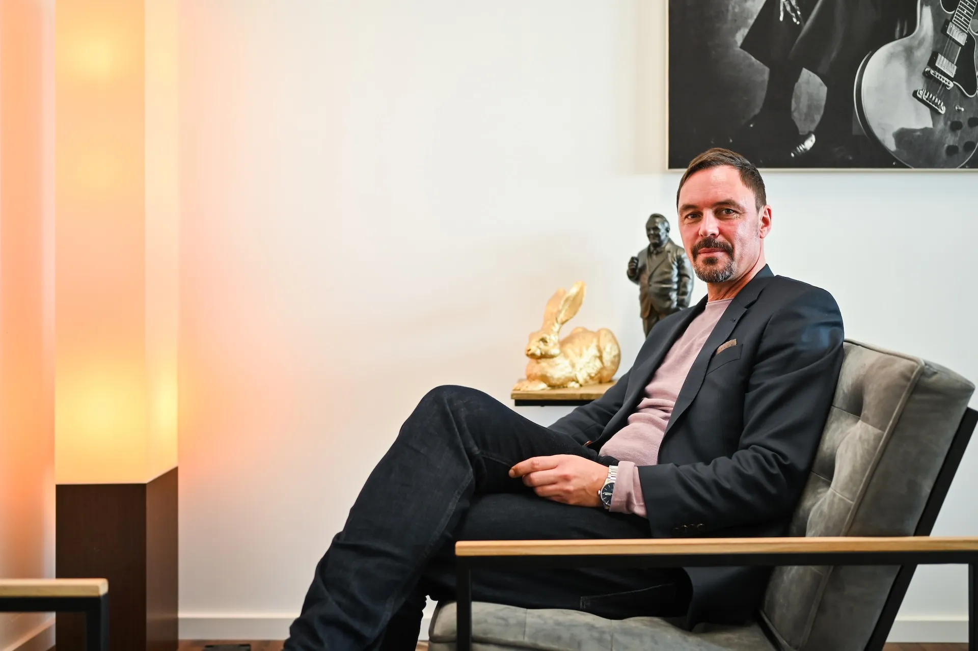 Businessportrait eines Mannes im Anzug auf einem Stuhl – seriös und modern.