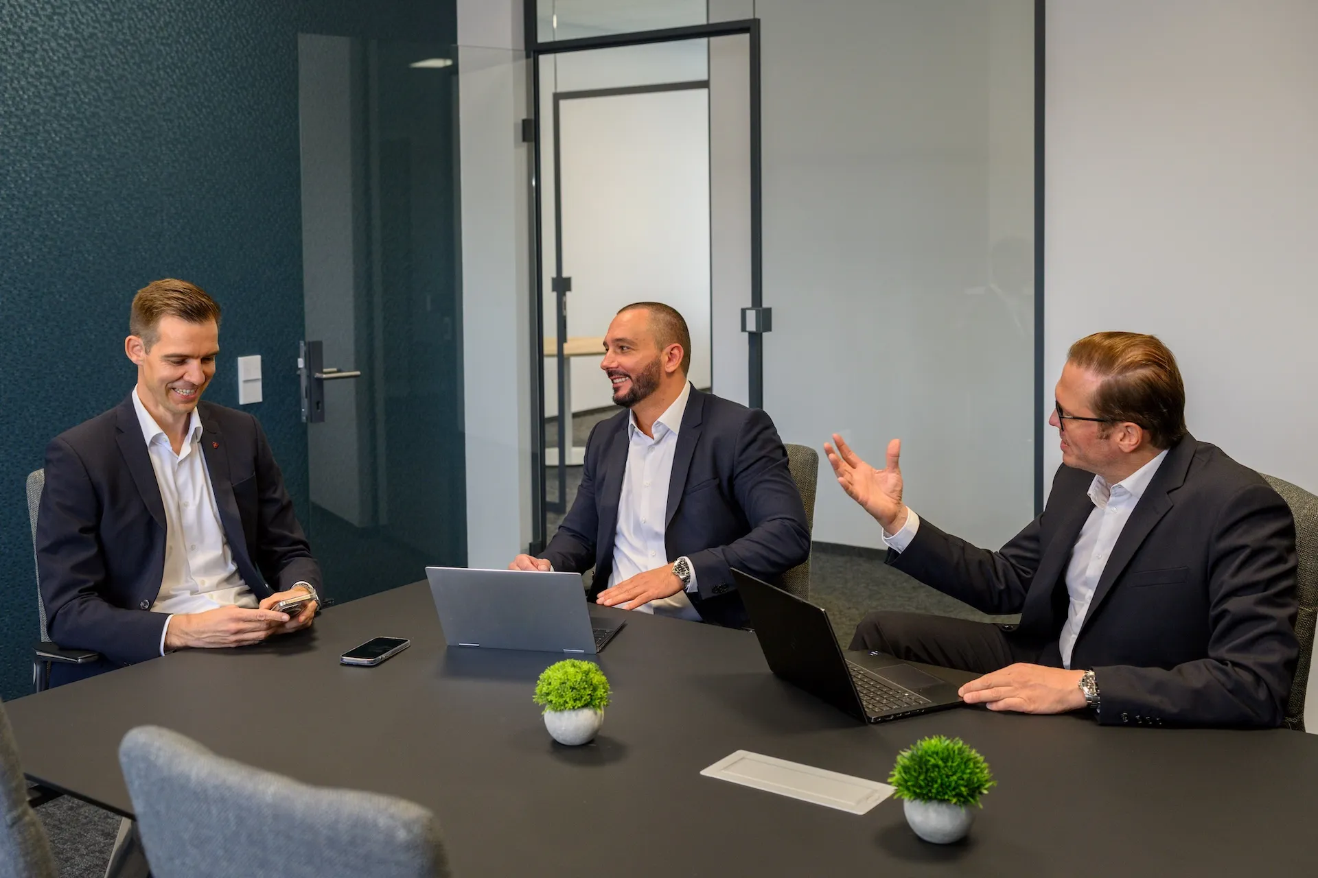 Drei Geschäftsleute im Besprechungsraum – Teamportrait mit Dynamik