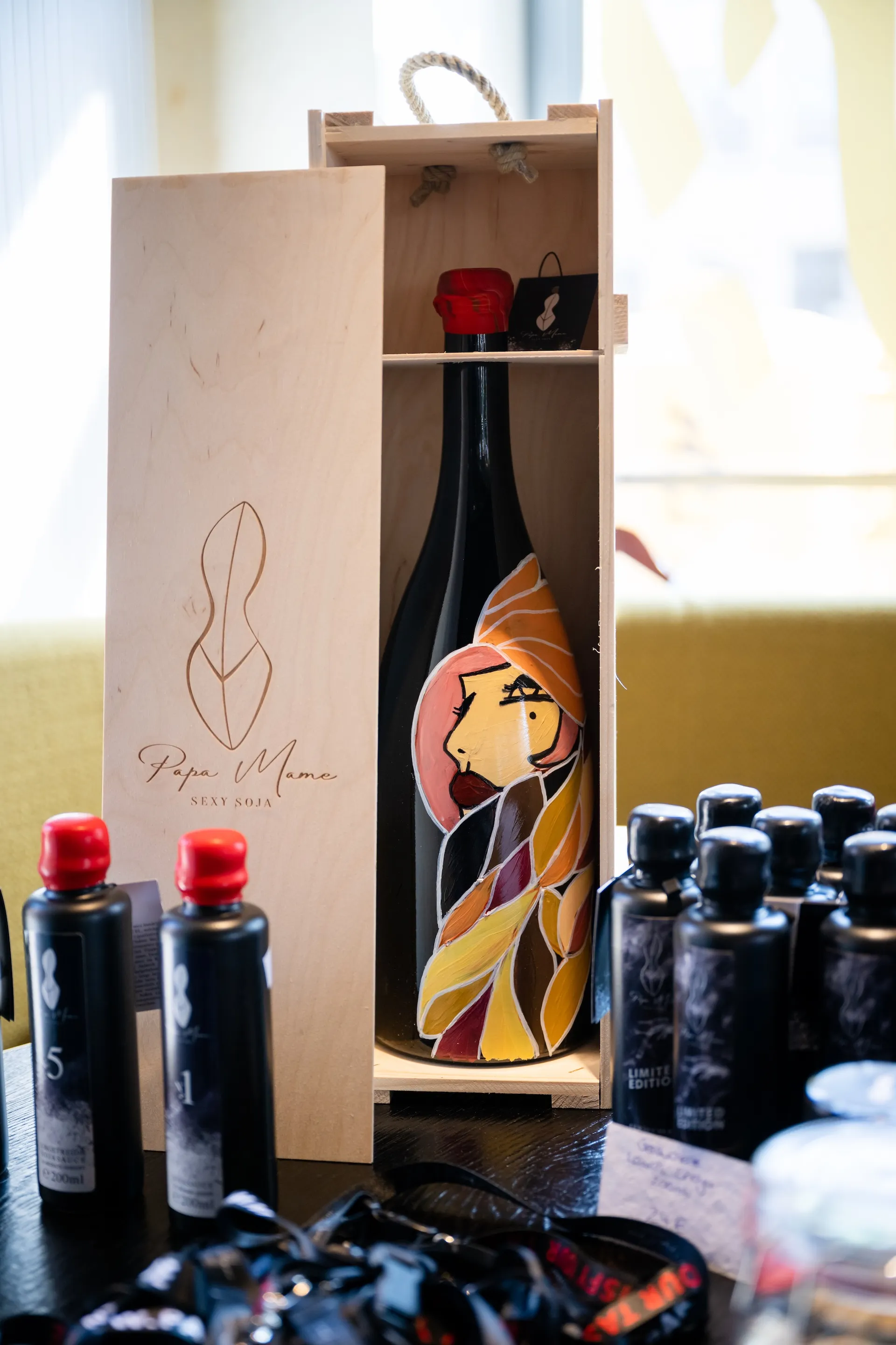 Weinflasche in handbemalter Holzkiste – hochwertig inszenierte Produktfotografie.