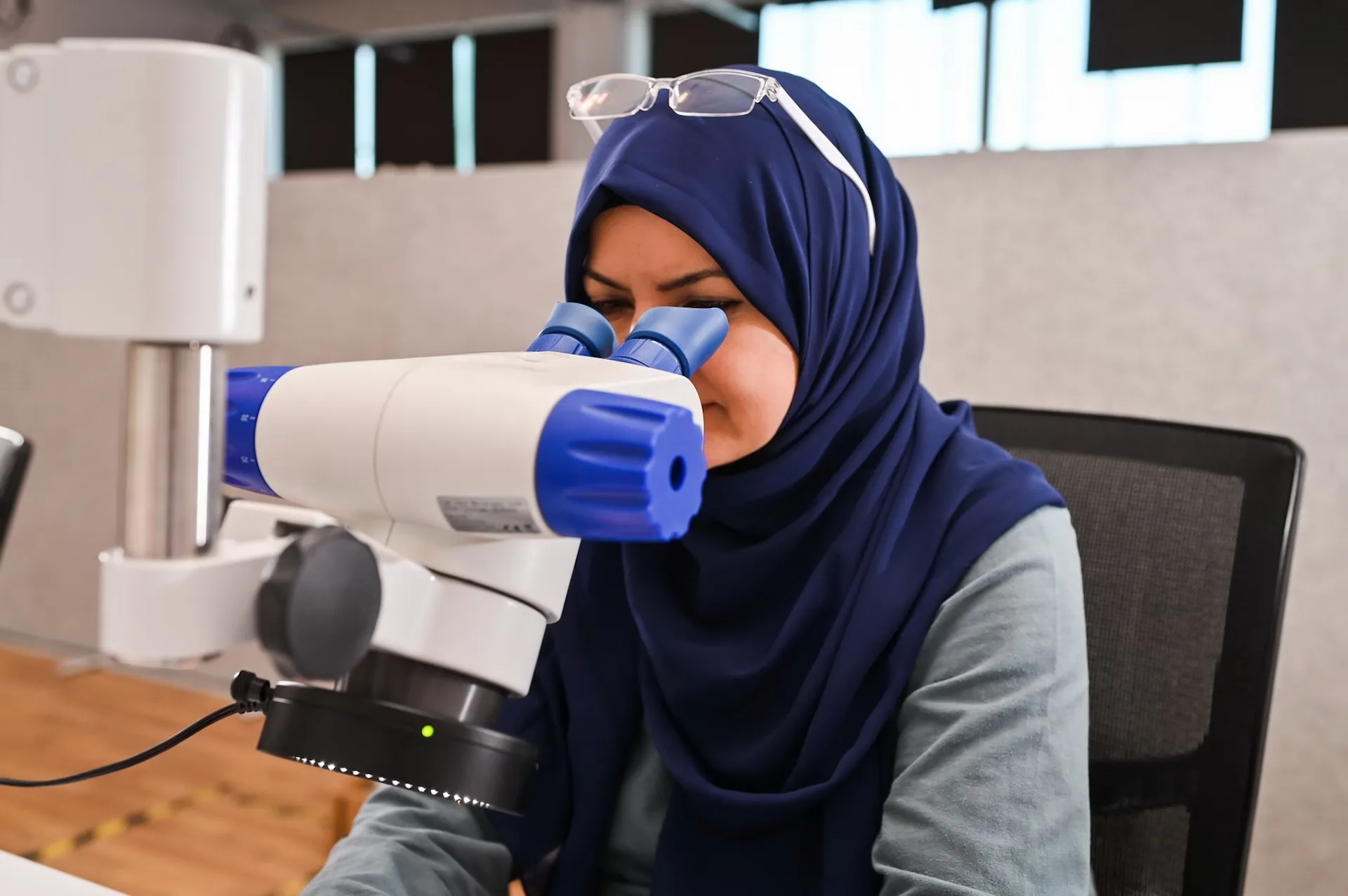 Mitarbeiterin am Mikroskop – Diversität und Forschung im Einklang.