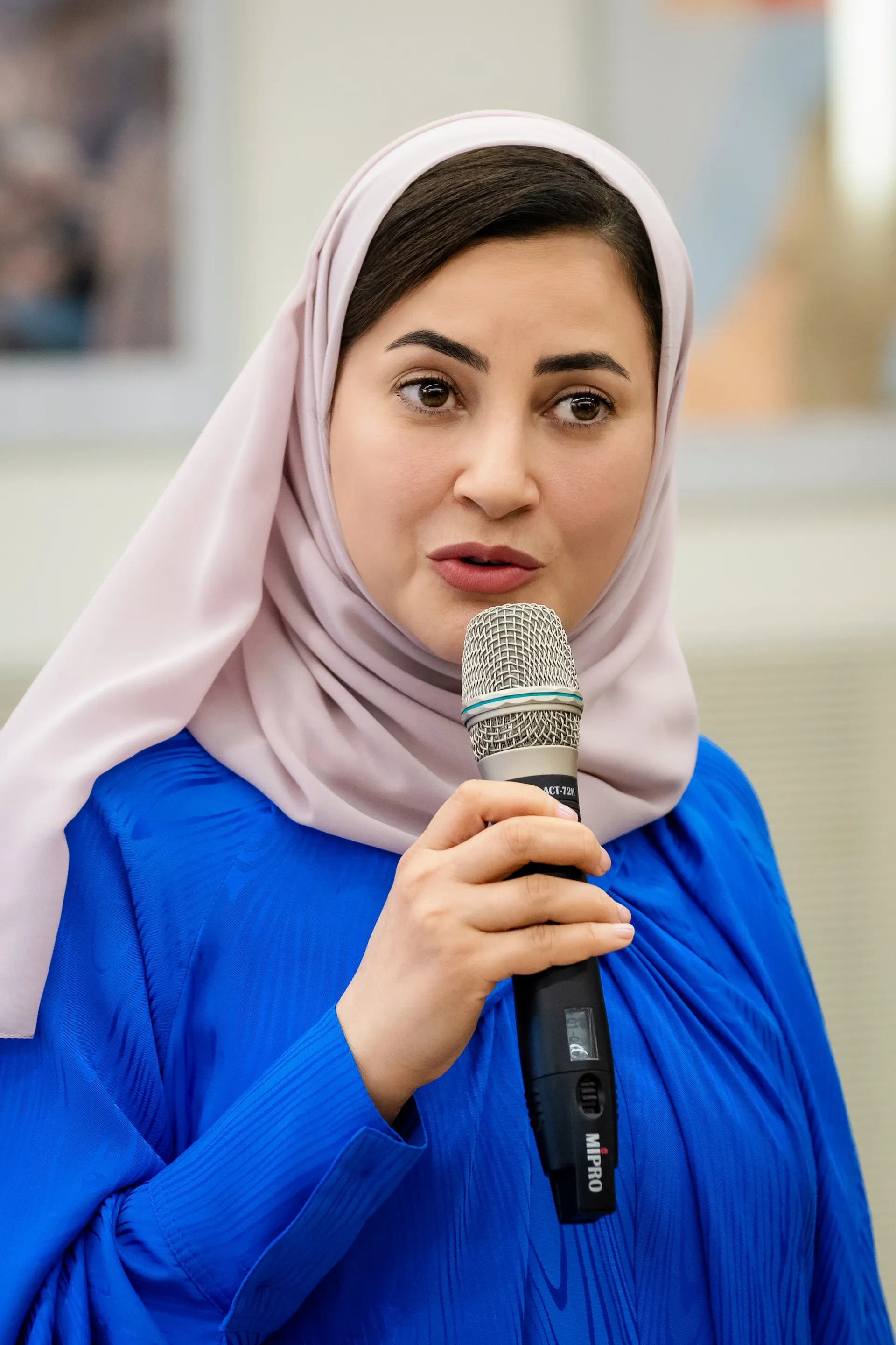 Frau mit Kopftuch spricht bei Firmenevent – starke Unternehmenskommunikation