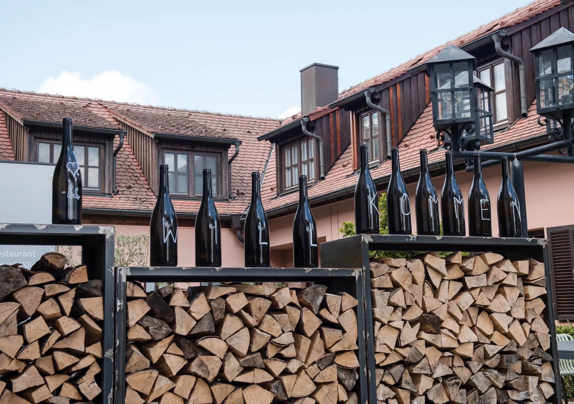 Gasthof Außenbereich mit dekorativen Weinflaschen – rustikaler Charme.
