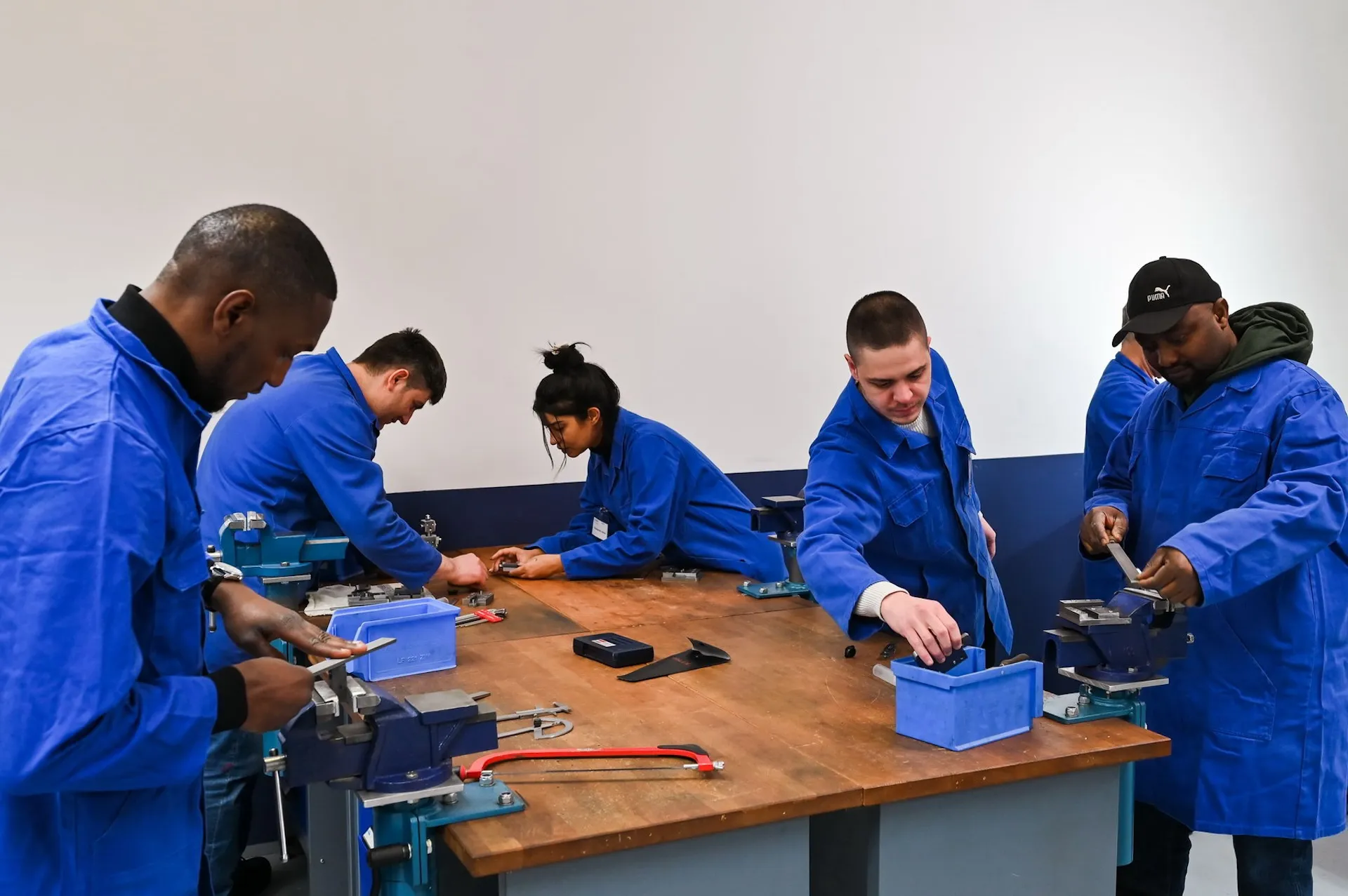 Auszubildende an der Werkbank – Teamarbeit und Nachwuchsförderung im Fokus.