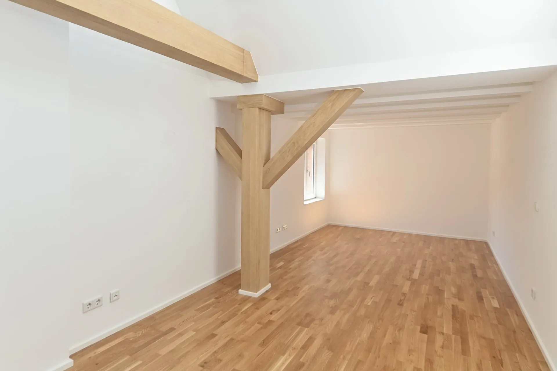 Loft-Dachgeschoss mit warmem Holzboden.