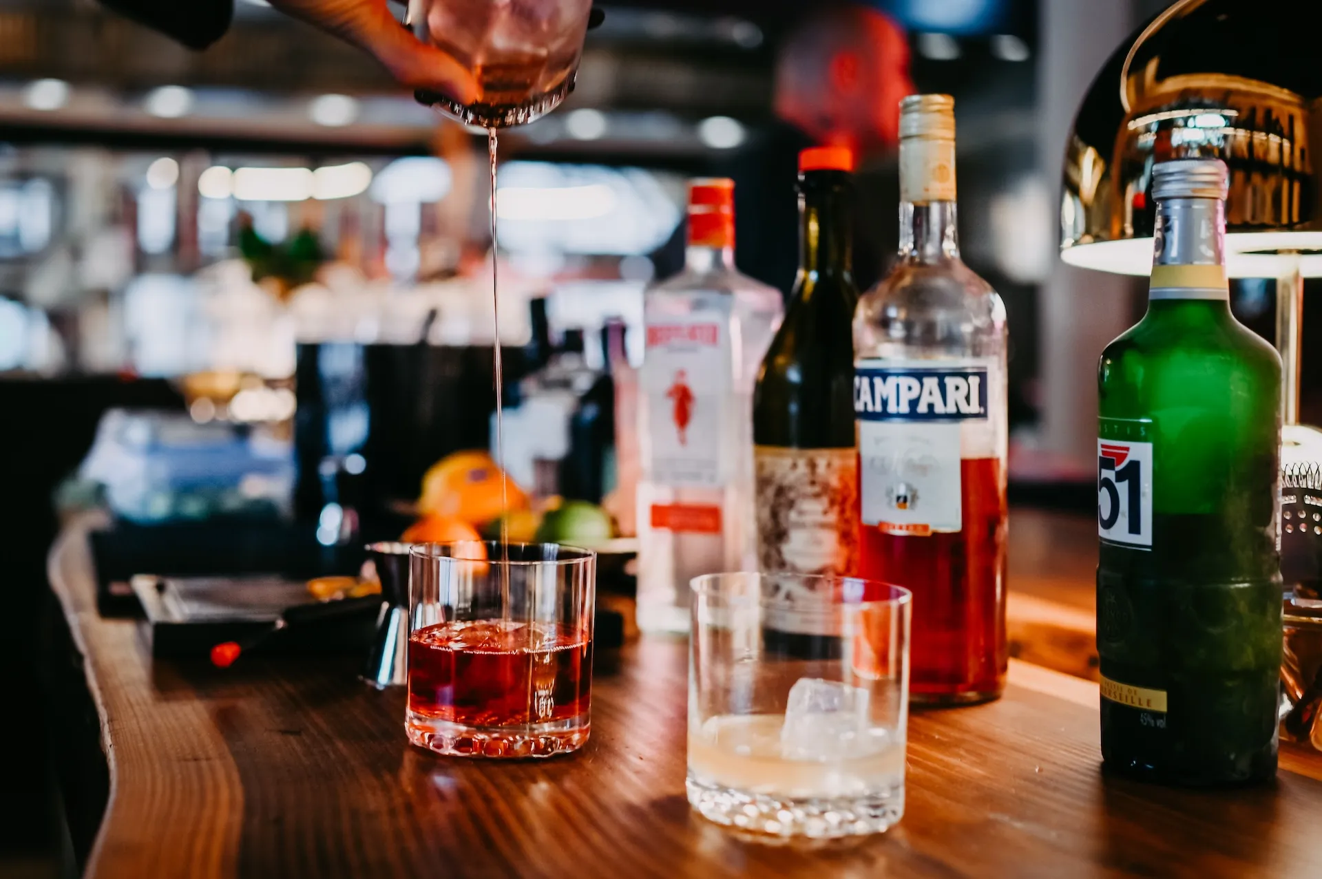 Longdrink-Mixer vor Bar-Hintergrund – Cocktailkunst in Aktion.