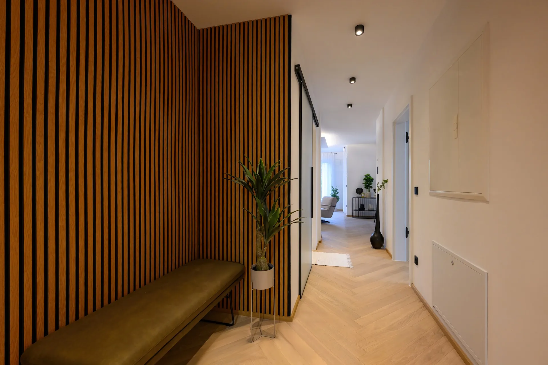 Wohnungsinterieur mit Holzlamellenwand – harmonisches Lichtspiel.